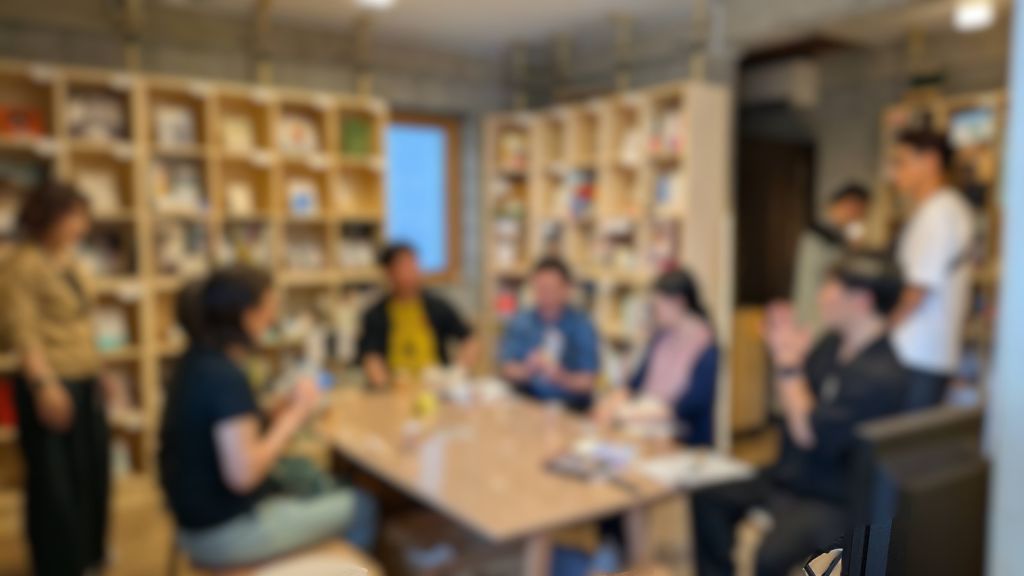 書店内でのトークイベントの様子（参加者が集まって歓談中）